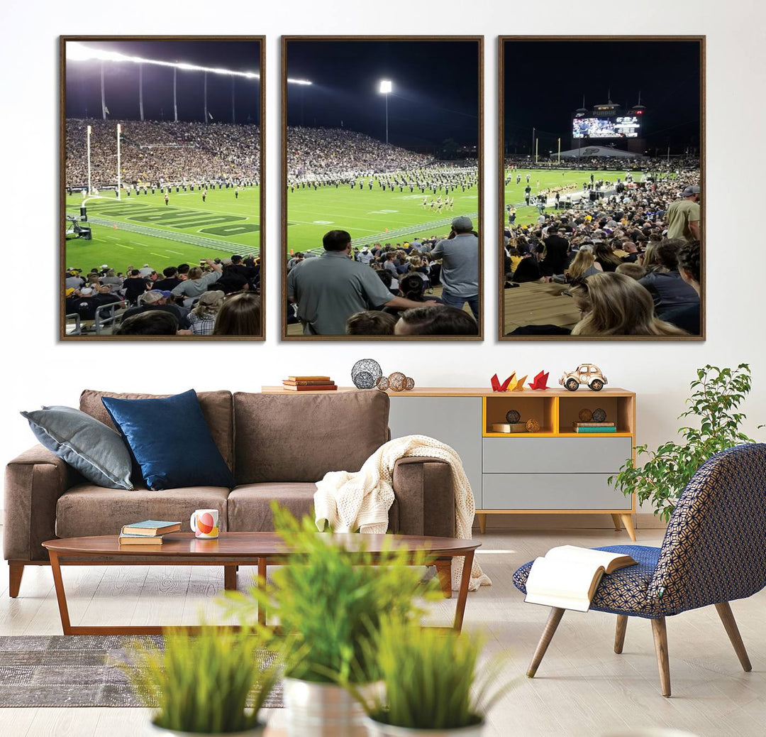 A painting depicting the Purdue Boilermakers football game at Ross-Ade Stadium is illuminated under gallery-quality lights.