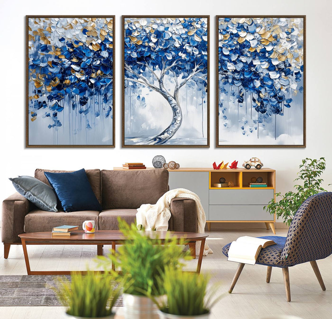 The Blue and Gold Abstract Tree Wall Art showcases a swirl trunk and features blue, silver, and gold leaves on a framed canvas print.