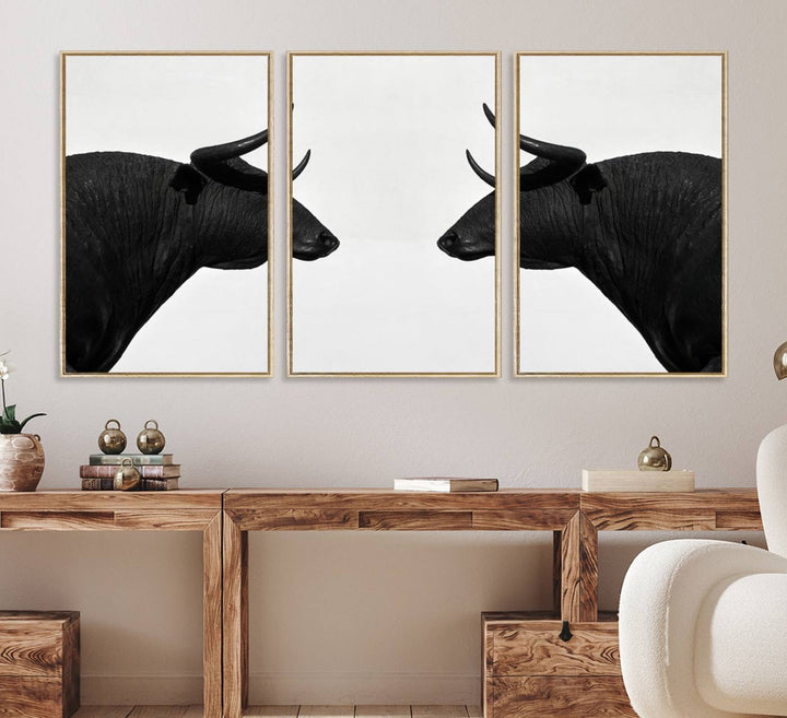 A framed canvas print featuring two black bull silhouettes, perfect for modern rustic decor.