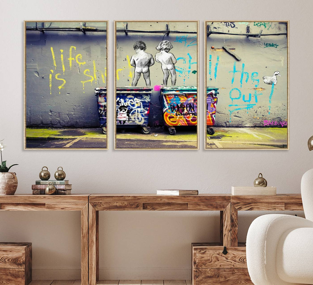 Banksys Life is Short graffiti, featuring kids and text, decorates the wall as a striking piece of framed canvas art.