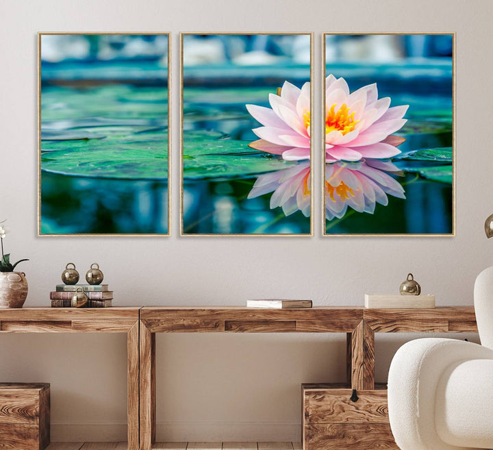 The Lotus Flower Canvas Print showcases a pink water lily with a yellow center gracefully floating on a calm pond.