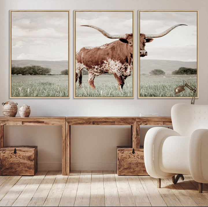 Canvas of a Texas longhorn standing in a grassy field with mountains in the background, ideal for rustic or country-style western wall decor.