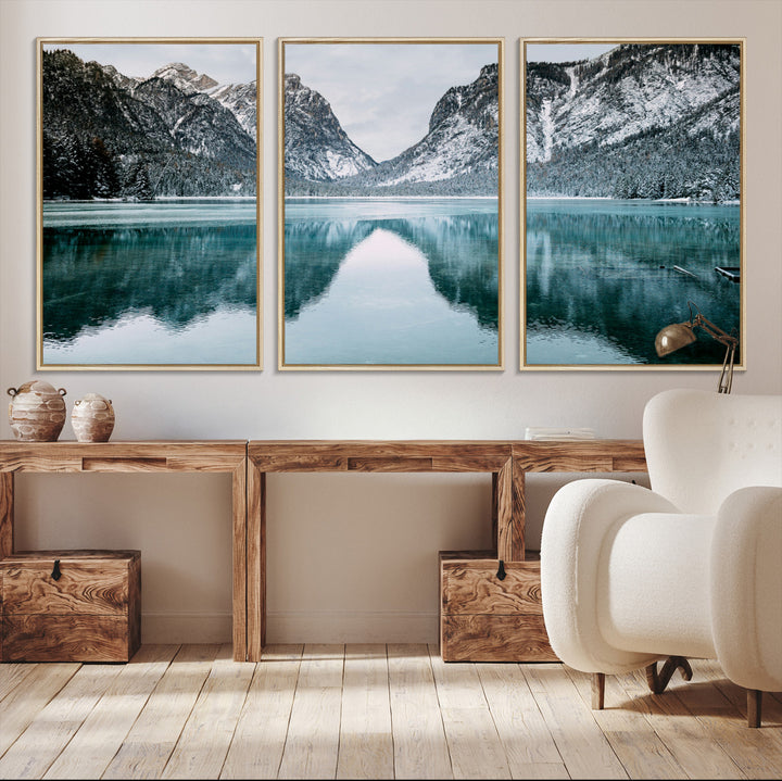 Crystal-clear alpine lake reflecting snow-covered mountains, surrounded by evergreen trees, creating a serene and tranquil winter landscape.