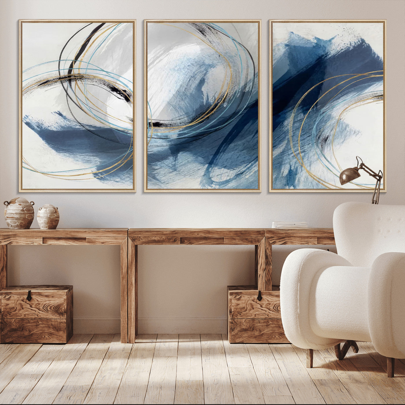 Abstract wall art featuring dynamic brush strokes in shades of blue and gray, overlaid with delicate circular line patterns in gold, black, and light blue on a white background.