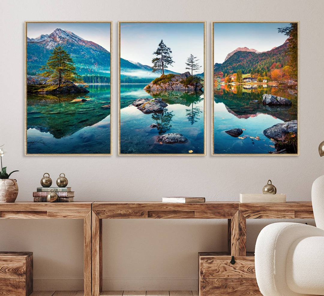 The 3-panel wall art showcases a serene mountain lake with rocky islands and trees, creating an ideal focal point for dining rooms or offices.