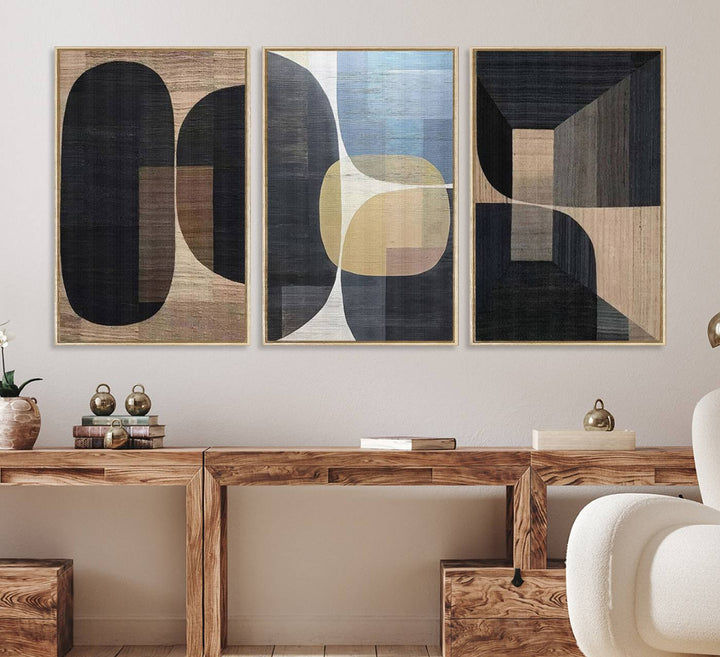 Abstract geometric wall art featuring black, gray, beige, and blue tones framed in a wooden border.