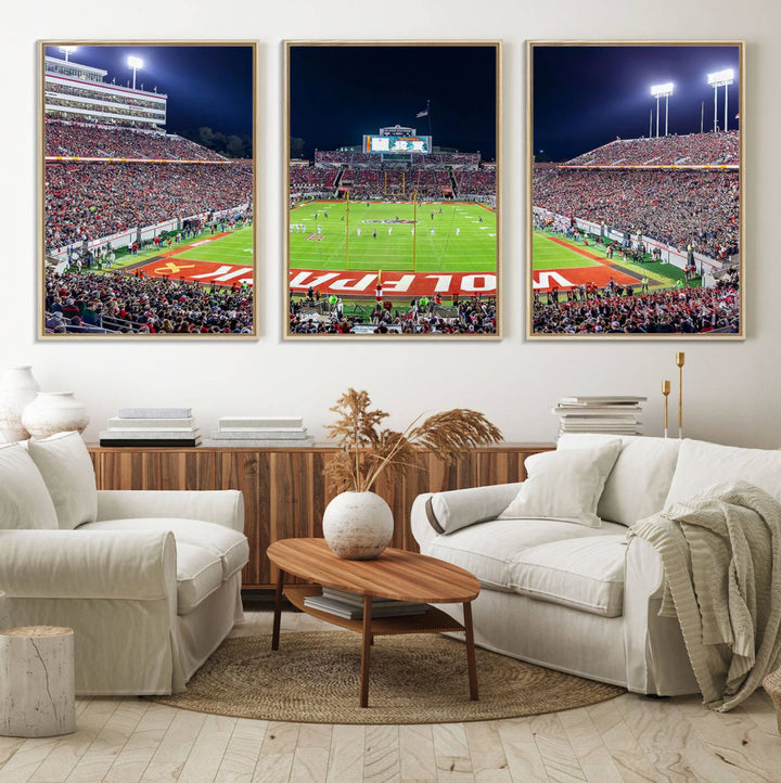 A NC State Wolfpack Football Team print of Carter-Finley Stadium at night features WOLFPACK illuminated brightly in the end zone grass.