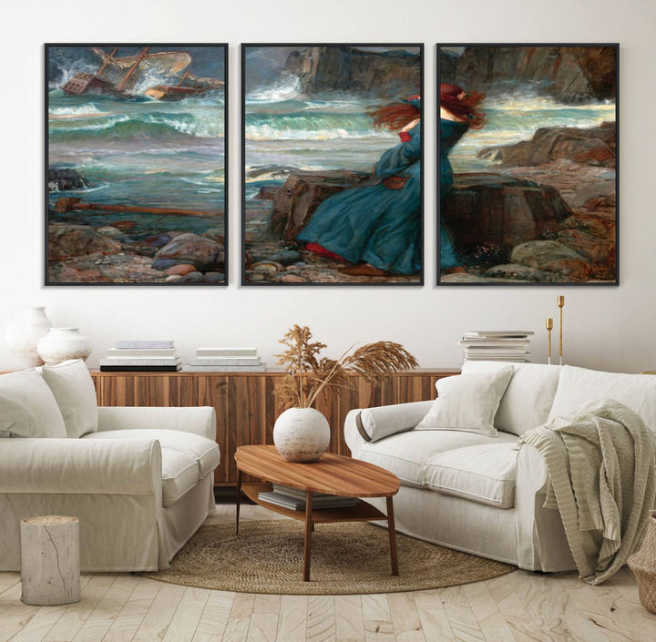 The Miranda by the Shore Wall Art Canvas Print depicts a woman in a blue dress standing by the sea, watching a shipwreck.