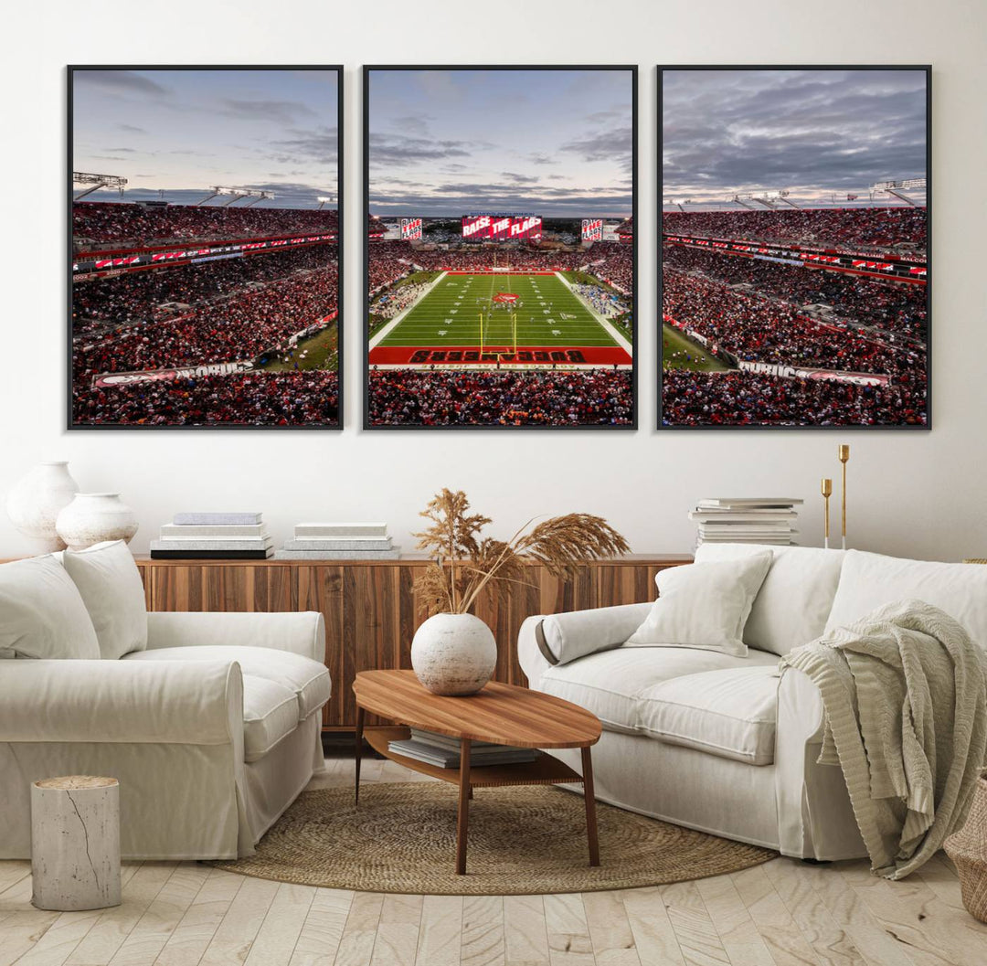 The wall art captures a stunning scene of Raymond James Stadium bathed in the warm hues of sunset. The sky, filled with clouds, provides a dramatic contrast to the vibrant lighting on the field, encapsulating the dynamic energy of a football game.