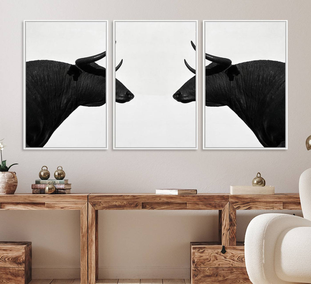 A framed canvas print featuring two black bull silhouettes, perfect for modern rustic decor.