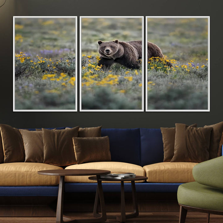 The "Grizzly 399 in Wild Flowers Wall Art Canvas Print" features a grizzly bear strolling through a field of yellow and purple flowers, beautifully showcased as a triptych. This handcrafted piece, proudly made in the USA, adds charm and sophistication to your space.