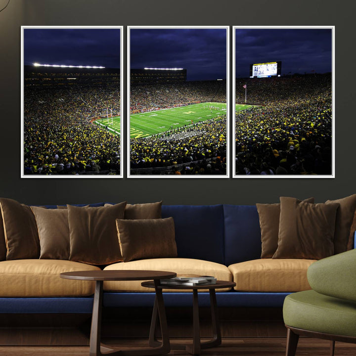 A painting of the packed Michigan Wolverines football stadium at night.