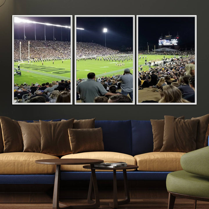 A painting depicting the Purdue Boilermakers football game at Ross-Ade Stadium is illuminated under gallery-quality lights.