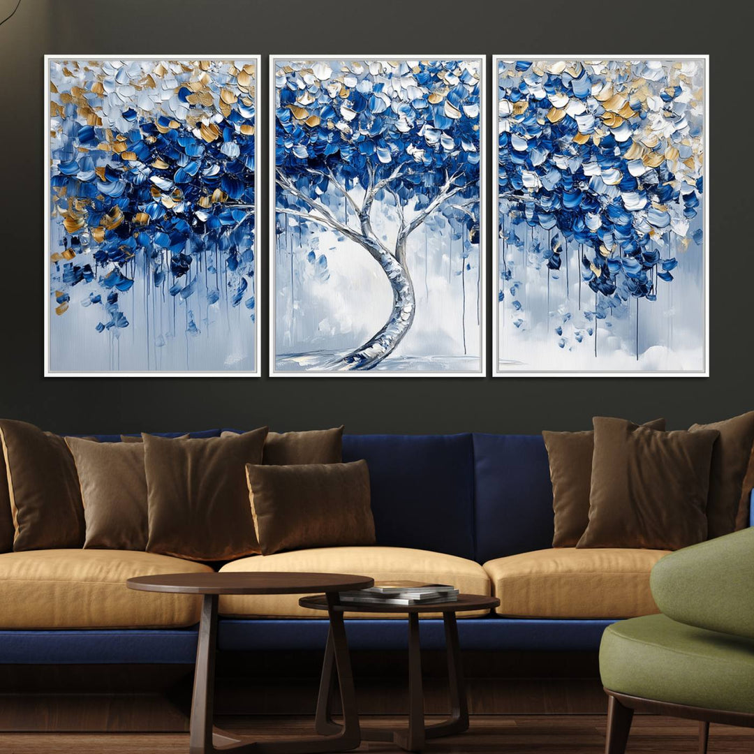 The Blue and Gold Abstract Tree Wall Art showcases a swirl trunk and features blue, silver, and gold leaves on a framed canvas print.