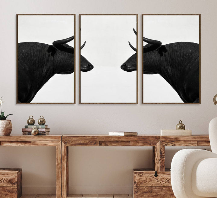 A framed canvas print featuring two black bull silhouettes, perfect for modern rustic decor.