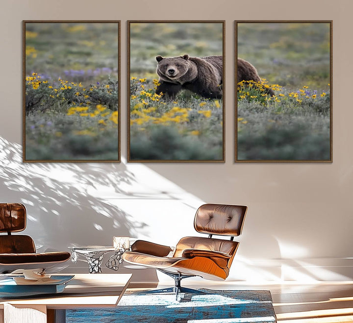 The "Grizzly 399 in Wild Flowers Wall Art Canvas Print" features a grizzly bear strolling through a field of yellow and purple flowers, beautifully showcased as a triptych. This handcrafted piece, proudly made in the USA, adds charm and sophistication to your space.