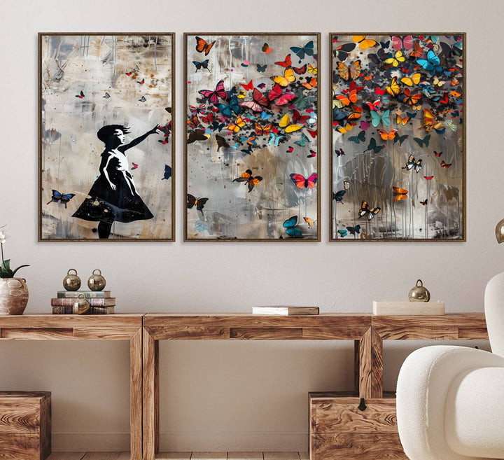 The Banksy Butterfly Girl 3-Piece Modern Graffiti Canvas Wall Art features a silhouette of a girl reaching for butterflies.