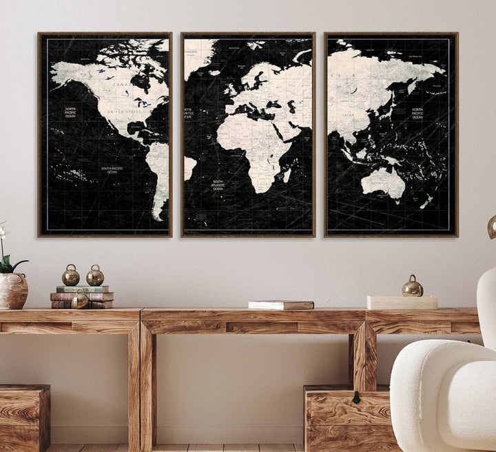 A bold global style framed black and white world map canvas print, presented in three panels, perfect for modern home or office decor.