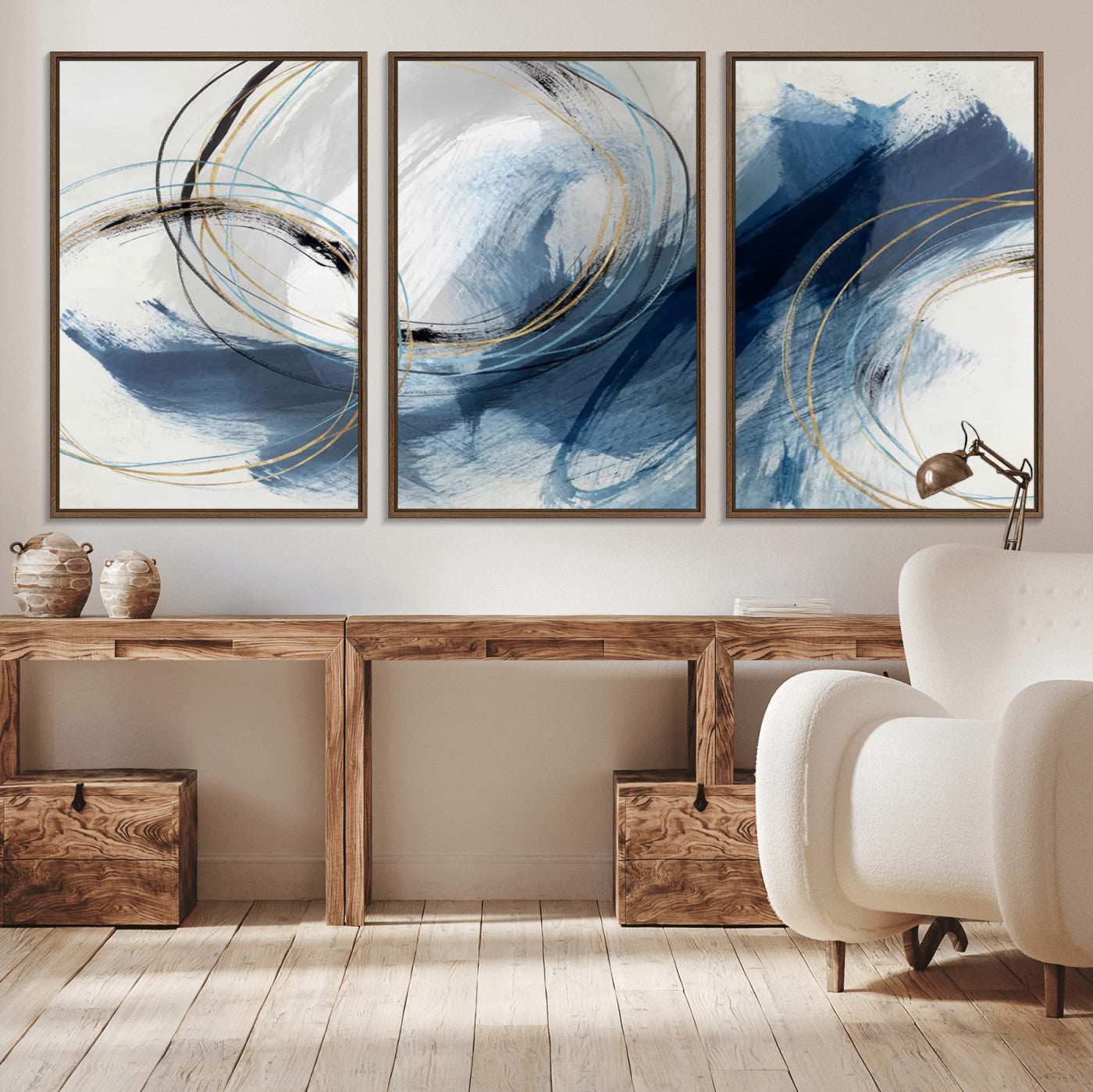 Abstract wall art featuring dynamic brush strokes in shades of blue and gray, overlaid with delicate circular line patterns in gold, black, and light blue on a white background.