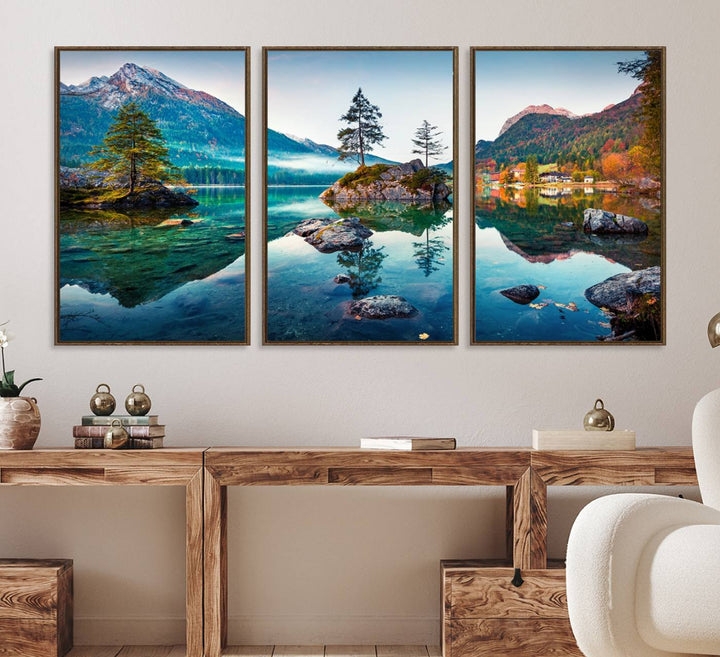 The 3-panel wall art showcases a serene mountain lake with rocky islands and trees, creating an ideal focal point for dining rooms or offices.