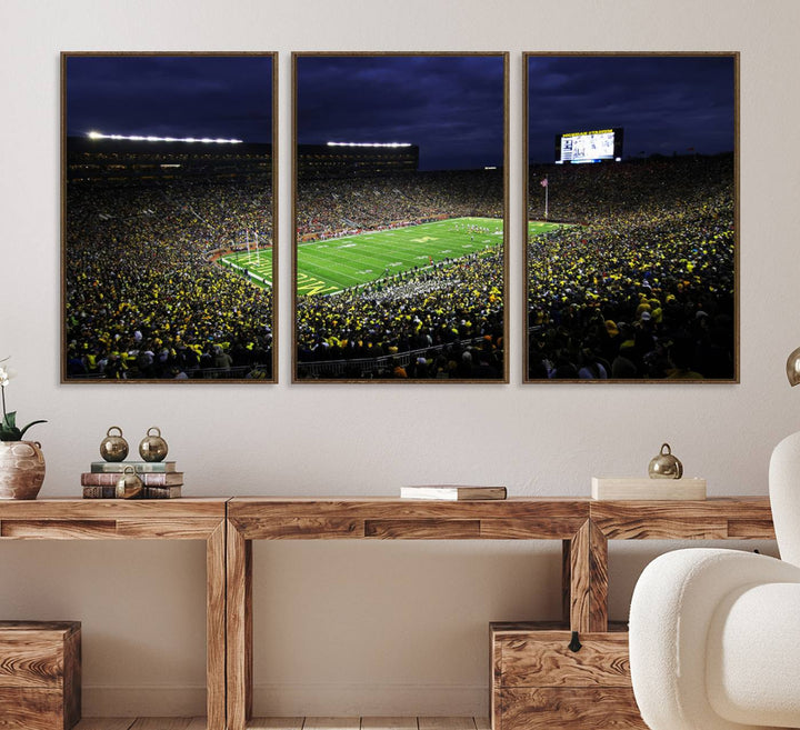 A painting of the packed Michigan Wolverines football stadium at night.