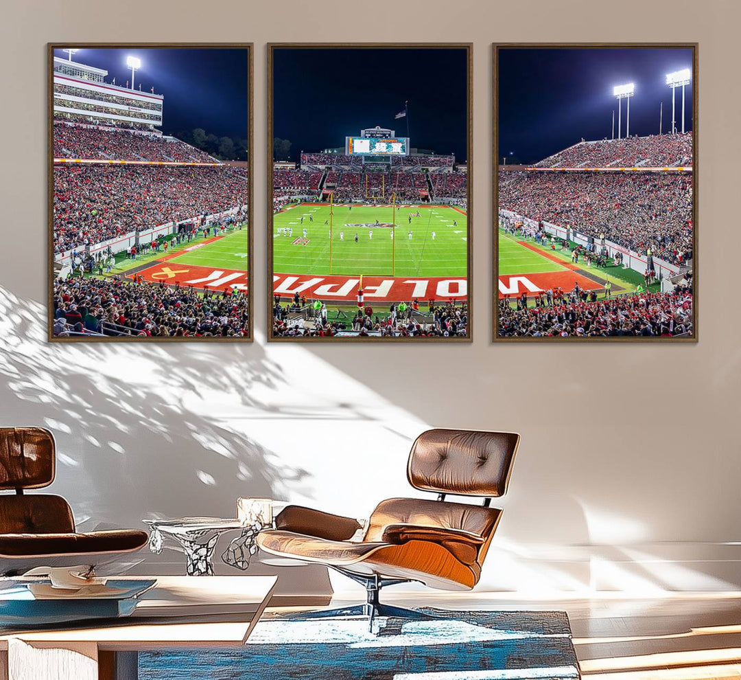 A NC State Wolfpack Football Team print of Carter-Finley Stadium at night features WOLFPACK illuminated brightly in the end zone grass.