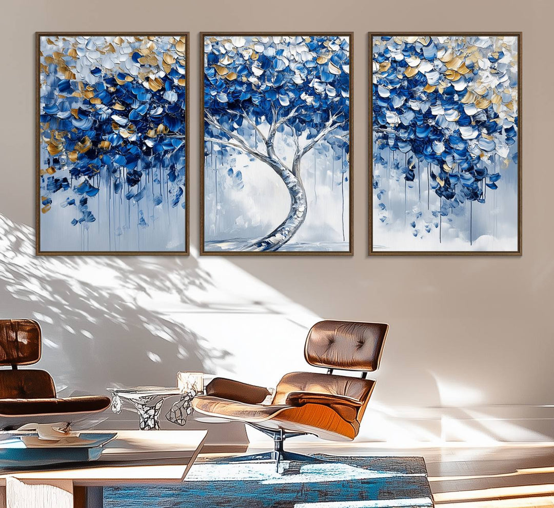 The Blue and Gold Abstract Tree Wall Art showcases a swirl trunk and features blue, silver, and gold leaves on a framed canvas print.