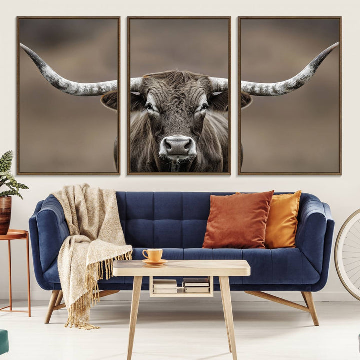 A close-up of a longhorn bull facing forward is featured in the Framed Texas Test-1, set against a blurred brown background.