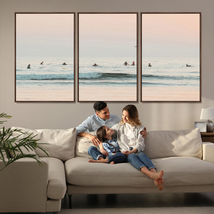 Dreamy photo of surfers waiting on soft pastel waves under a pink sunset sky, ideal for soft coastal minimalist or serene ocean-themed home decor.