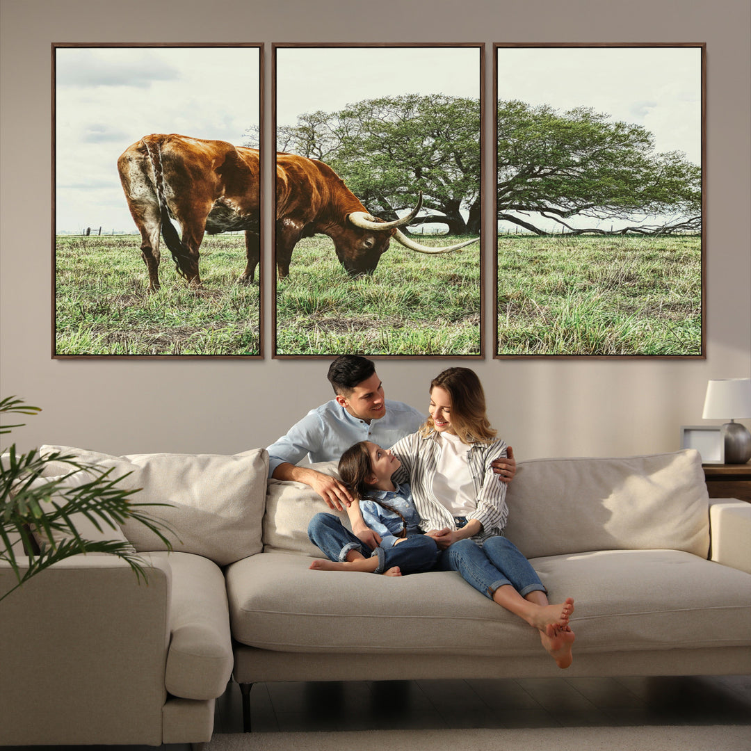A Texas Longhorn grazing in a green pasture with a large tree in the background, evoking a rustic Western and farmhouse aesthetic.