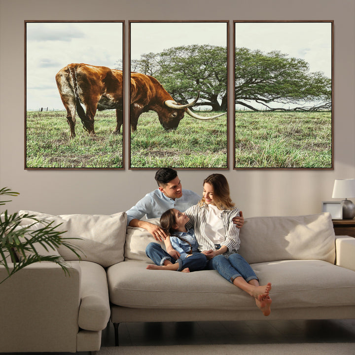 A Texas Longhorn grazing in a green pasture with a large tree in the background, evoking a rustic Western and farmhouse aesthetic.