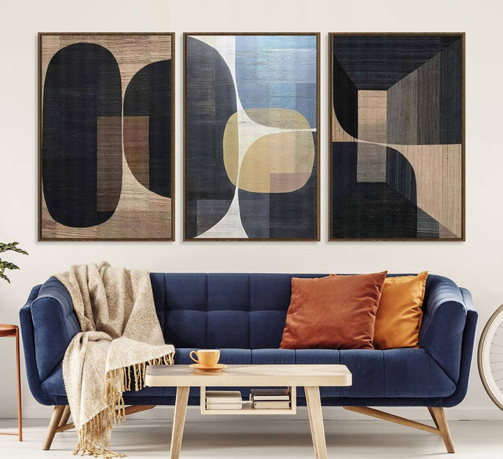 Abstract geometric wall art featuring black, gray, beige, and blue tones framed in a wooden border.