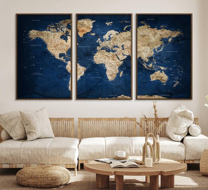 A large framed world map canvas print features beige landmasses set against a grunge-stained deep blue ocean background, creating an intriguing piece of wall art.