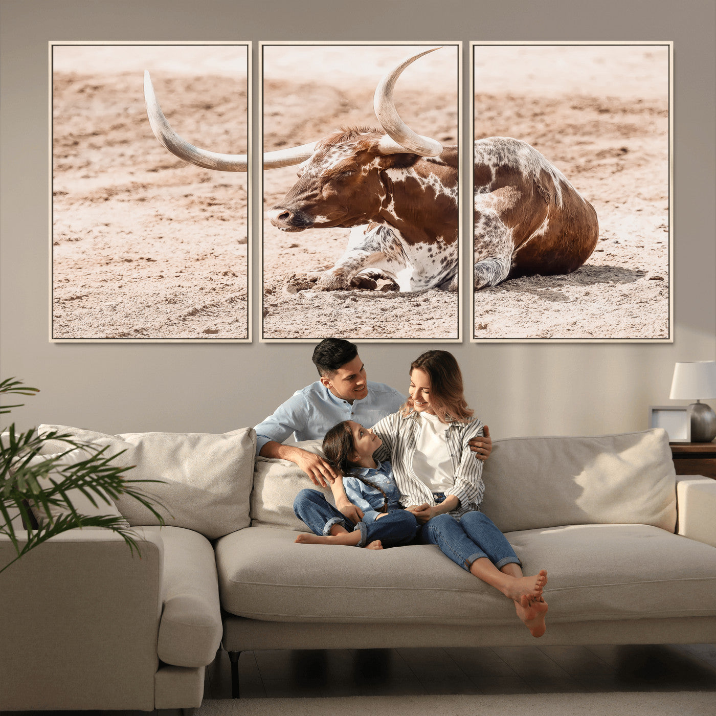 Texas Longhorn bull resting on dusty ground with warm tones, ideal for rustic western or farmhouse-themed wall decor.