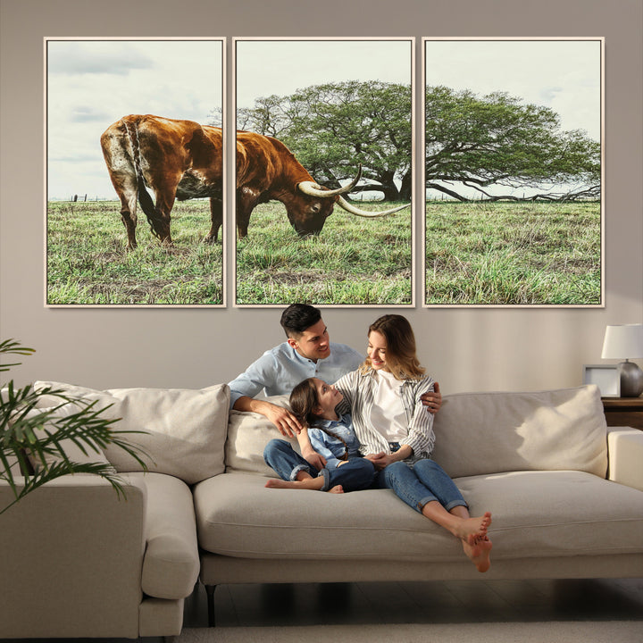 A Texas Longhorn grazing in a green pasture with a large tree in the background, evoking a rustic Western and farmhouse aesthetic.