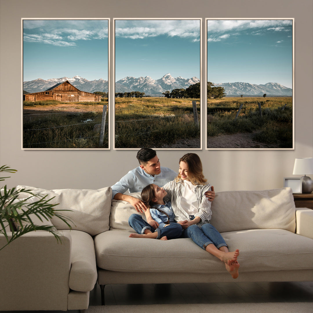 A rustic farmhouse with a wooden barn set against majestic mountain peaks under a soft blue sky, evoking peaceful countryside charm.