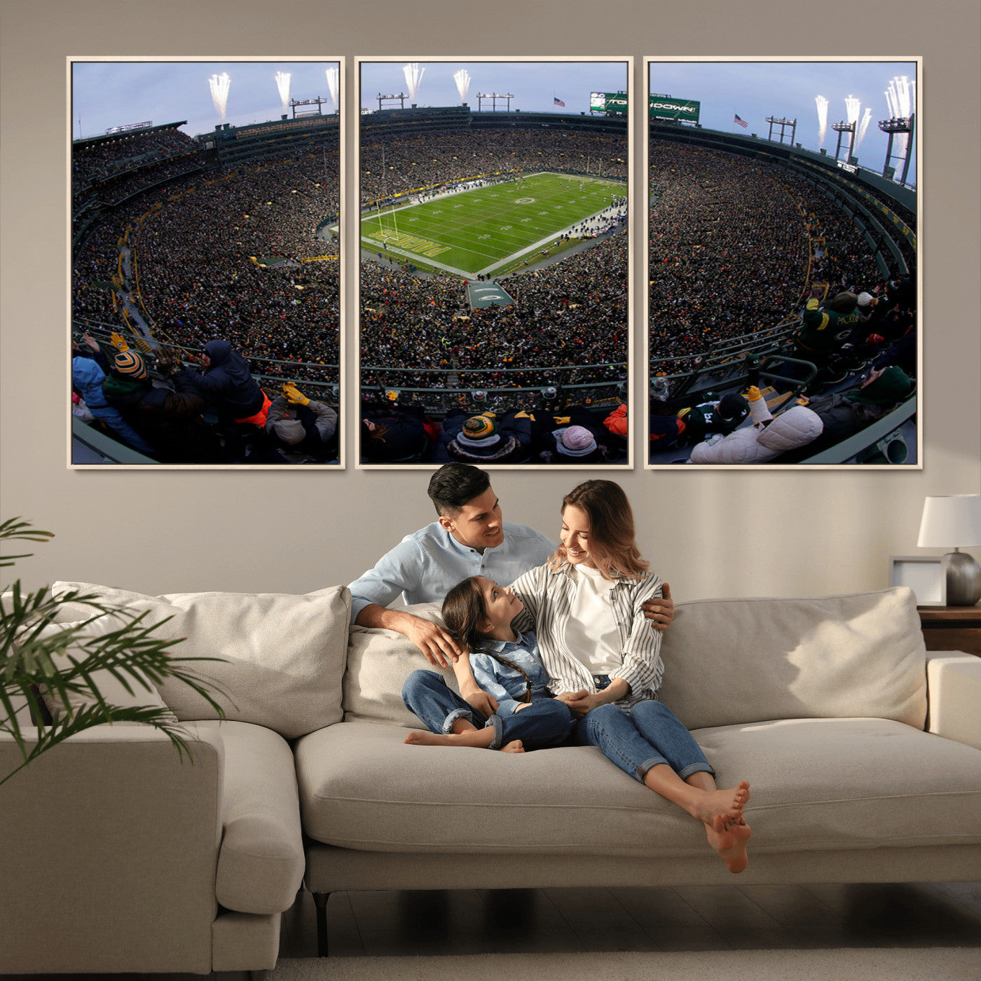 Wide fisheye view of a packed Lambeau Field stadium during an American football game. The crowd fills the stands, and fireworks are going off above the stadium lights. The scoreboard displays "Touchdown," and the field has "Packers" painted in the end zon