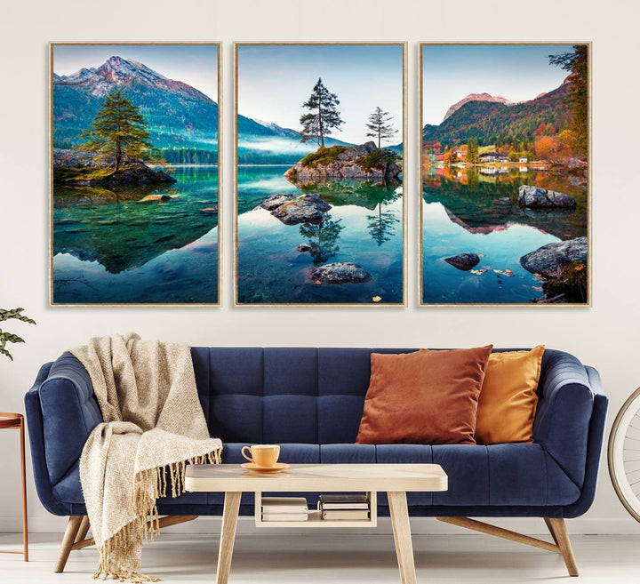 The 3-panel wall art showcases a serene mountain lake with rocky islands and trees, creating an ideal focal point for dining rooms or offices.