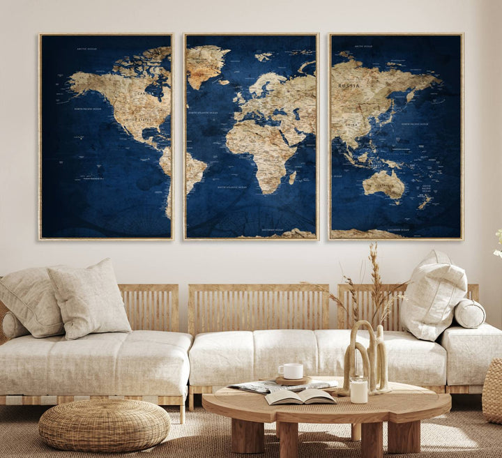 A large framed world map canvas print features beige landmasses set against a grunge-stained deep blue ocean background, creating an intriguing piece of wall art.