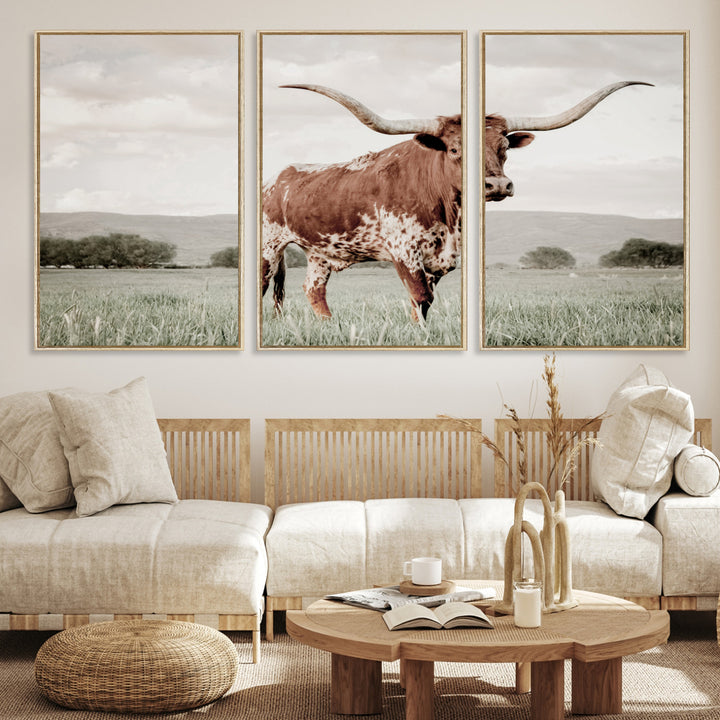 Canvas of a Texas longhorn standing in a grassy field with mountains in the background, ideal for rustic or country-style western wall decor.