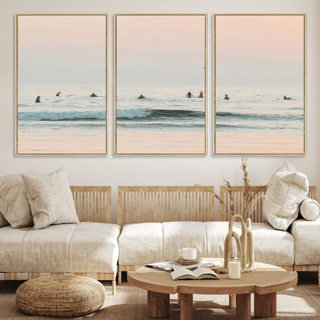 Dreamy photo of surfers waiting on soft pastel waves under a pink sunset sky, ideal for soft coastal minimalist or serene ocean-themed home decor.