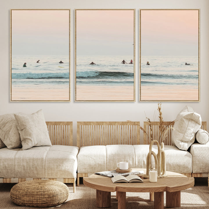 Dreamy photo of surfers waiting on soft pastel waves under a pink sunset sky, ideal for soft coastal minimalist or serene ocean-themed home decor.