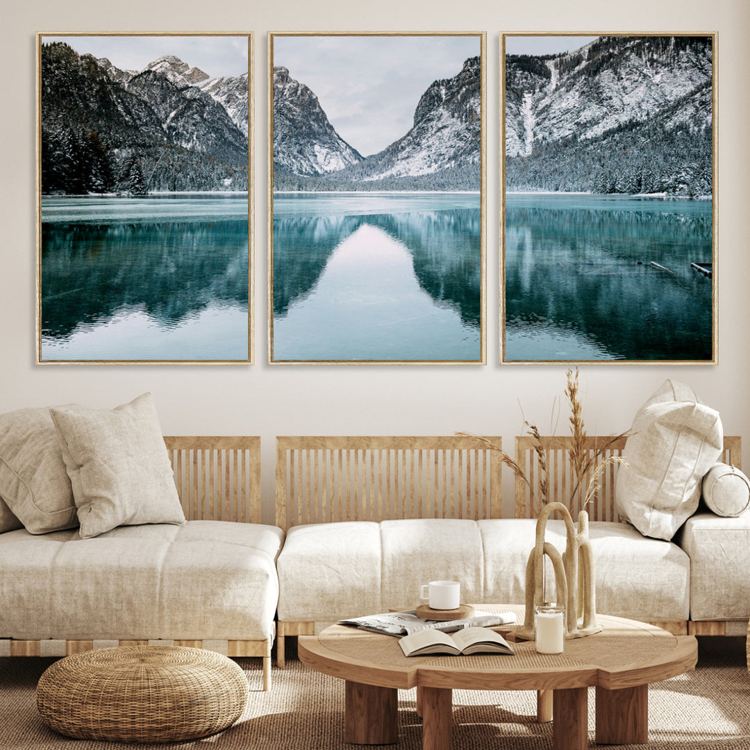 Crystal-clear alpine lake reflecting snow-covered mountains, surrounded by evergreen trees, creating a serene and tranquil winter landscape.