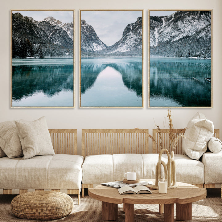 Crystal-clear alpine lake reflecting snow-covered mountains, surrounded by evergreen trees, creating a serene and tranquil winter landscape.