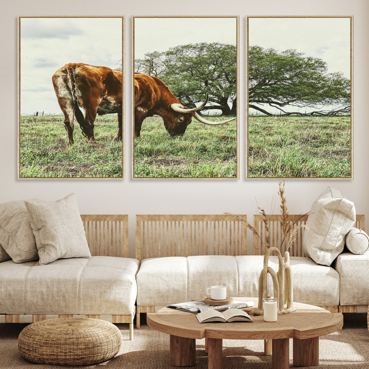 A Texas Longhorn grazing in a green pasture with a large tree in the background, evoking a rustic Western and farmhouse aesthetic.