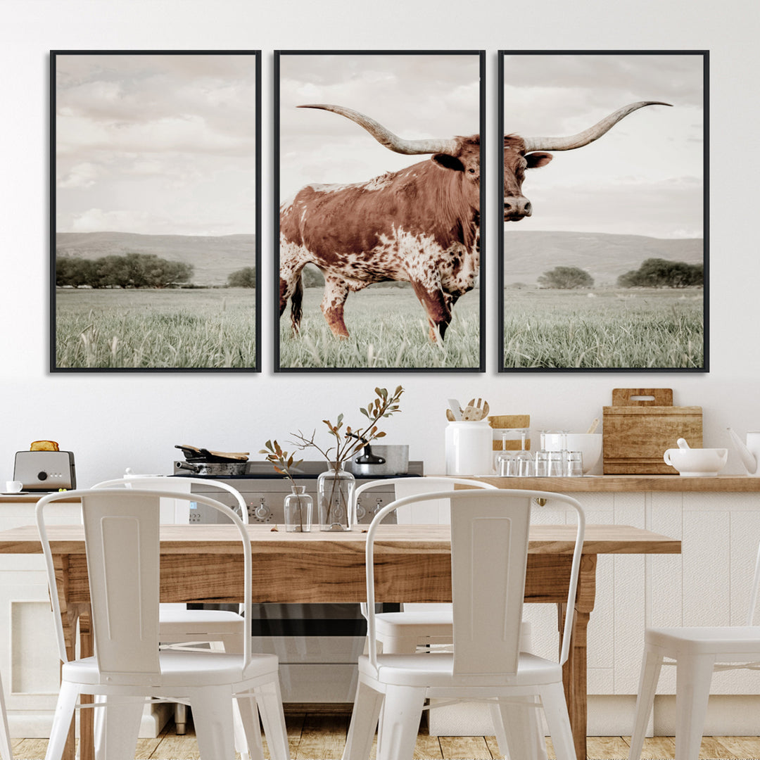 Canvas of a Texas longhorn standing in a grassy field with mountains in the background, ideal for rustic or country-style western wall decor.