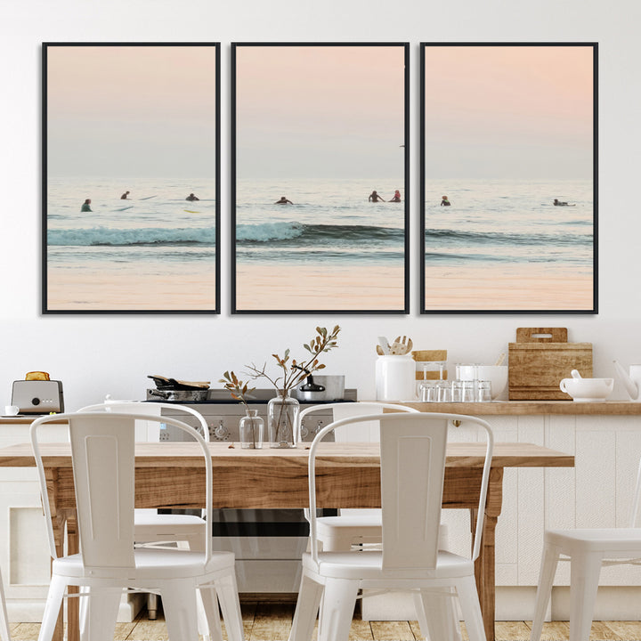 Dreamy photo of surfers waiting on soft pastel waves under a pink sunset sky, ideal for soft coastal minimalist or serene ocean-themed home decor.