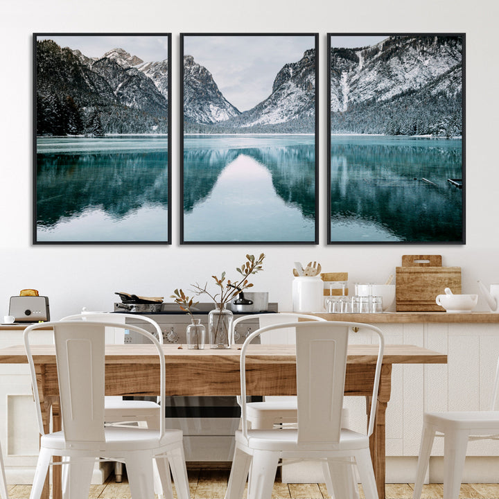 Crystal-clear alpine lake reflecting snow-covered mountains, surrounded by evergreen trees, creating a serene and tranquil winter landscape.