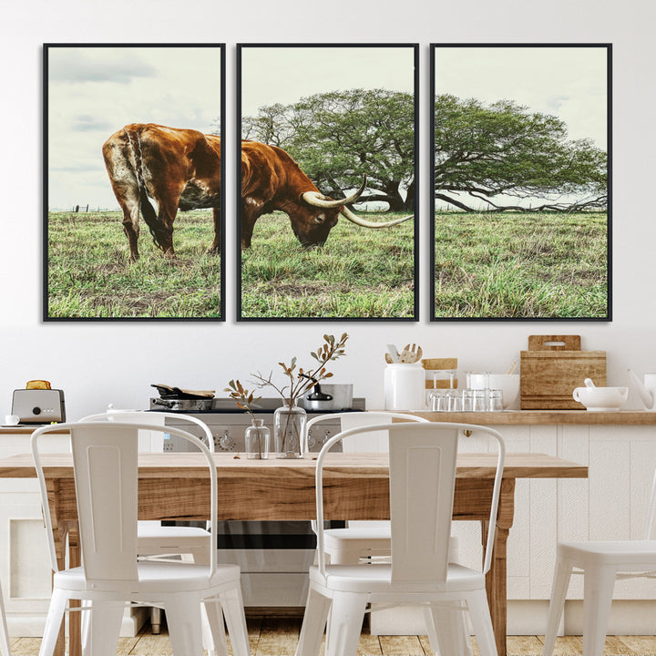 A Texas Longhorn grazing in a green pasture with a large tree in the background, evoking a rustic Western and farmhouse aesthetic.