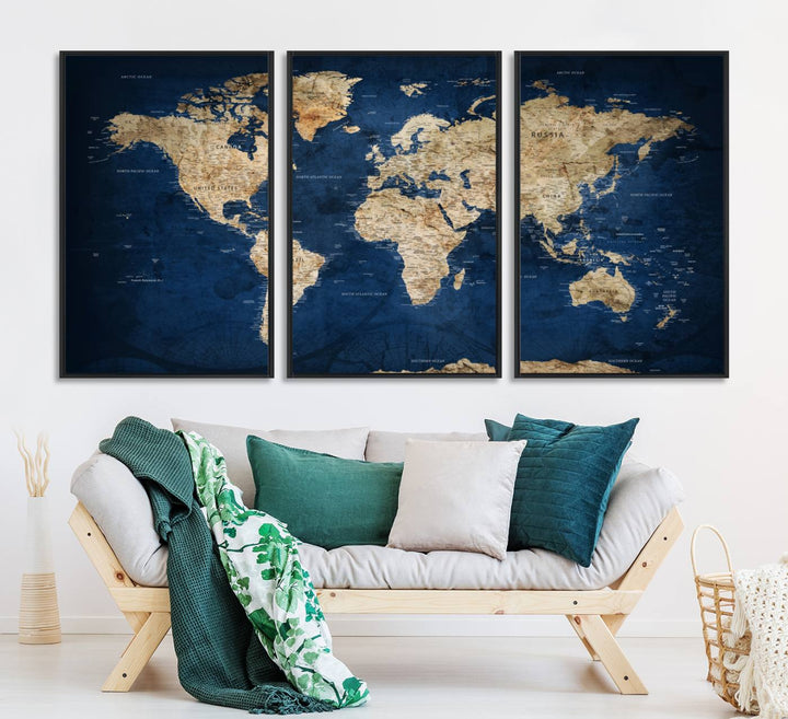 A large framed world map canvas print features beige landmasses set against a grunge-stained deep blue ocean background, creating an intriguing piece of wall art.